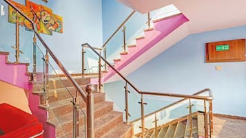 A staircase with glass railings and a fire exit sign.