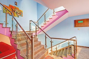 Una escalera con barandillas de vidrio y un letrero de salida de incendios.