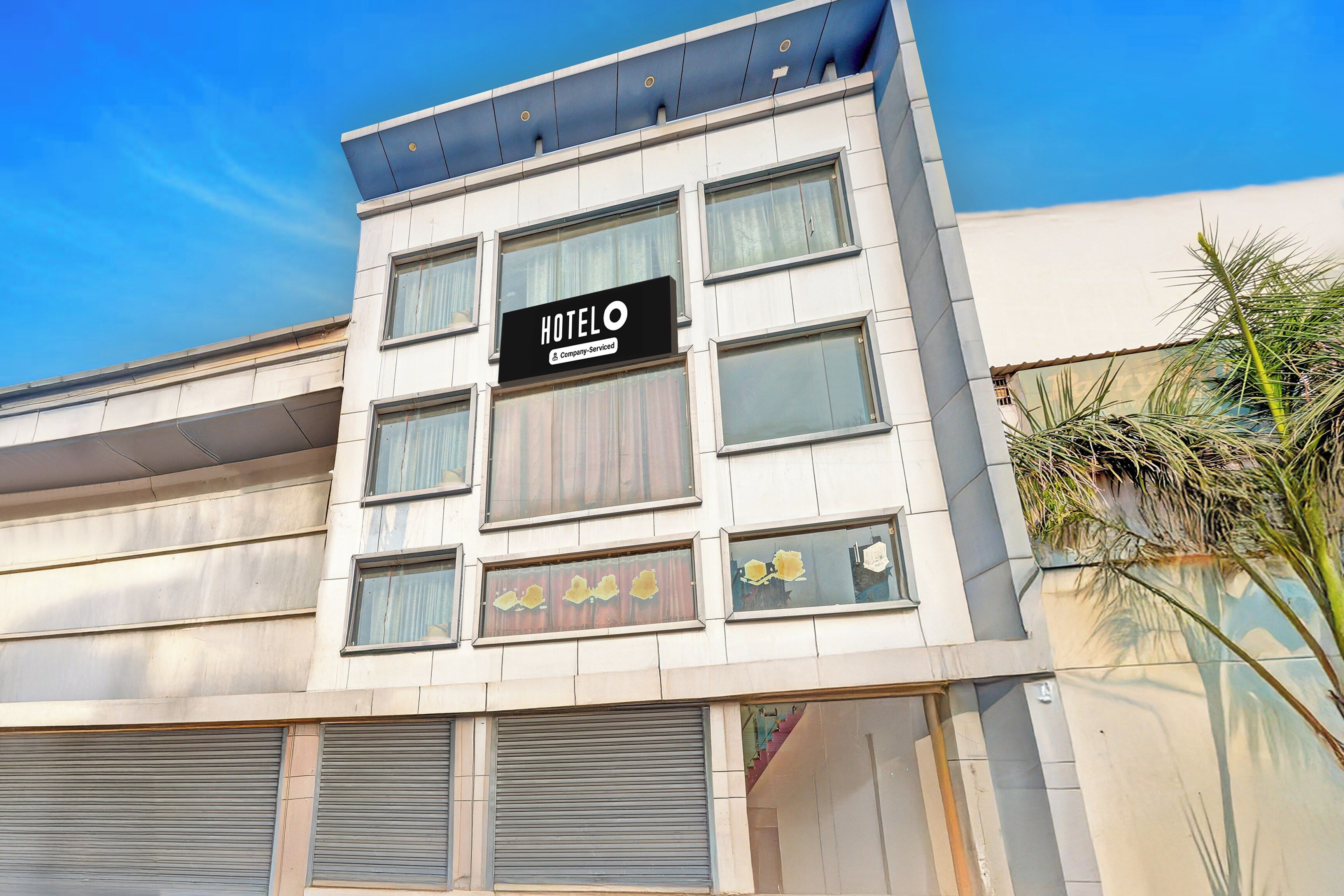 Un bâtiment d’hôtel avec une enseigne indiquant : « Hôtel O Company, services inclus ».