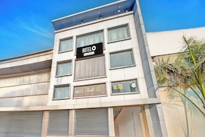 A hotel building with a sign that reads 'HOTEL O Company Serviced'.