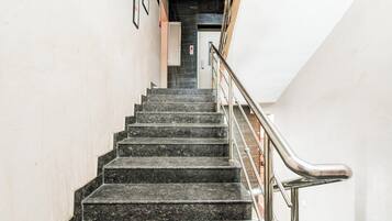 Eine Treppe mit Handlauf, die zu einem Aufzug führt.
