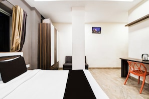 A hotel room with a bed, a desk, a chair, and a small picture on the wall. - Hotel O Raipur City Center (Raipur)