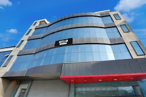 Un moderno edificio de hotel con fachada curva, grandes ventanales y un llamativo letrero que dice 'HOTEL'.