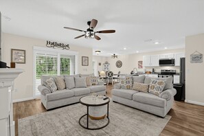 A modern living room with a sectional sofa, a round coffee table, and a ceiling fan. - Chef's Kitchen Family Basecamp Inverness 3 Bedroom Home (Inverness)