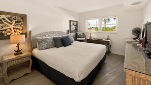 Una camera da letto con un letto, comodini, una lampada, una sedia, una scrivania e una finestra vista.