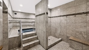 A modern bathroom with a marble floor, a built-in bathtub, and a shower area with a glass door. - 525 El Matador 1 Bedroom Condo (Fort Walton Beach)