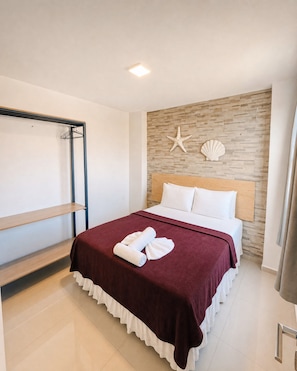 A hotel room with a bed, a wooden headboard, a wall with a stone pattern, and a starfish decoration. - VG Fun Praia do Futuro (Fortaleza)