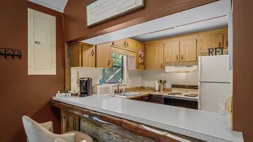 A kitchen with wooden cabinets, a white countertop, and a coffee machine.