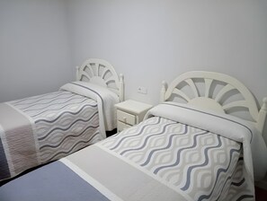 A twin room with two single beds, each with a headboard and a bedside table. - Apartment 'Alojamiento Rural La Tahona Gorafe' with Wi-Fi (Gorafe)