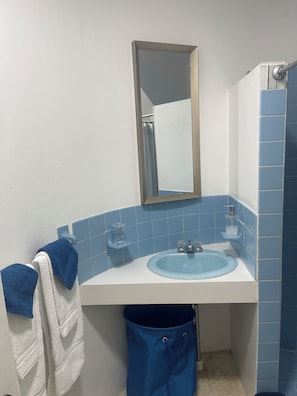A bathroom with a white sink, blue tiles, a mirror, and a towel rack. - Perfect 3-bedroom townhome with AC in charming Exchange Ocho Rios (Ocho Rios)