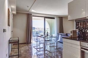 A modern kitchen with a dining area, a sofa, and a view of the city. - Mercury Suites 2BR Luxury Hideaway, Pool Access (St. Julian's)