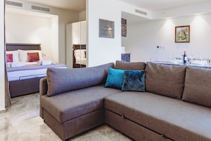 A modern hotel room with a sofa, a bed, a dining area, and a bathroom. - Mercury Suites 2BR Luxury Hideaway, Pool Access (St. Julian's)