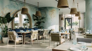 Comedor moderno con iluminación colgante de mimbre, asientos cómodos y ventanas amplias que ofrecen vistas.