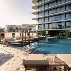 A rooftop pool area with lounge chairs and a modern building with balconies. - Mercury Suites 2BR Luxury Hideaway, Pool Access (St. Julian's)