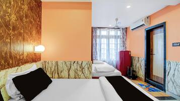 A hotel room with two beds, a marble-patterned wall, a window with curtains, an air conditioning unit, and a door with a handle.