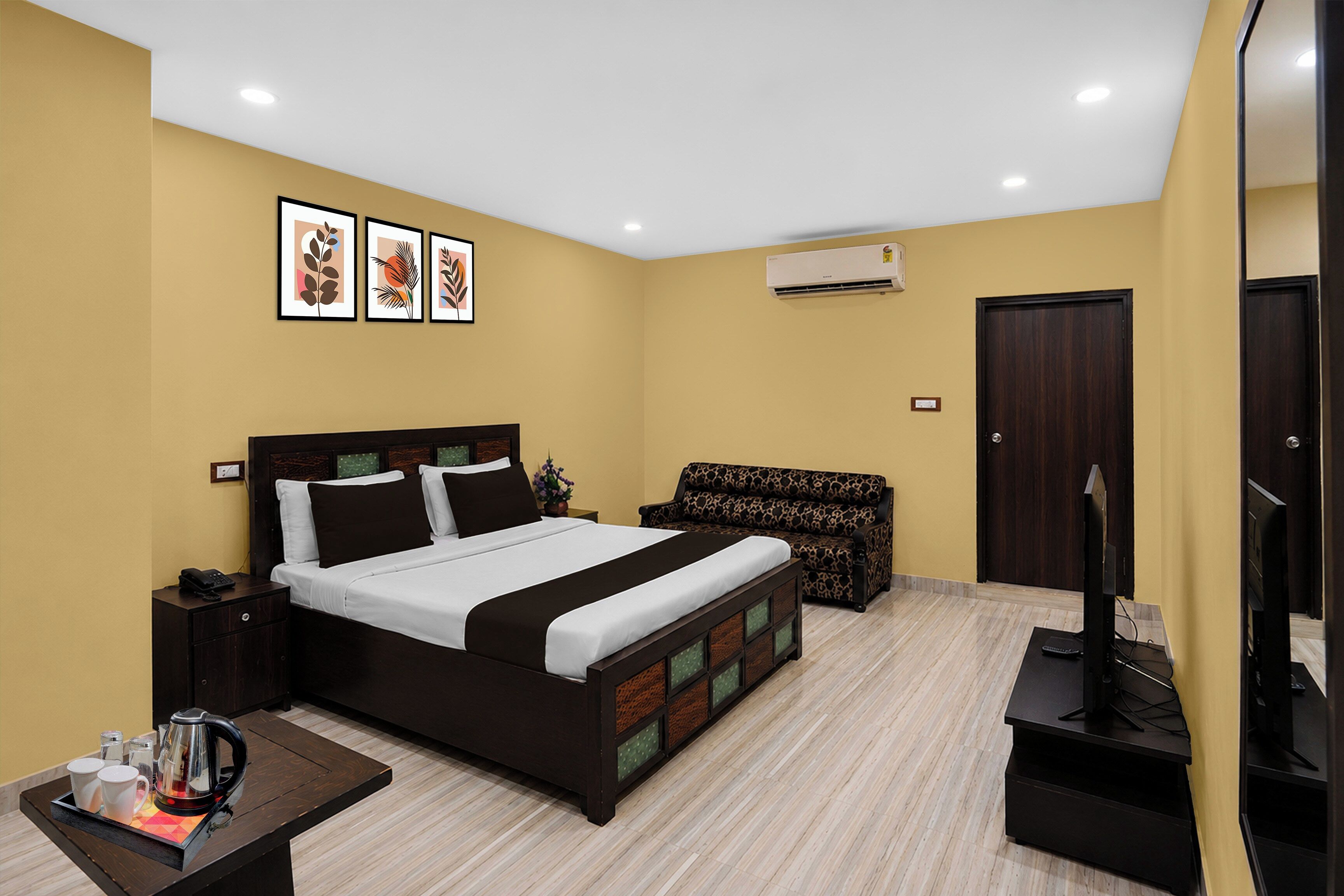 Una habitación de hotel con cama, mesita de noche, lámpara y televisión.