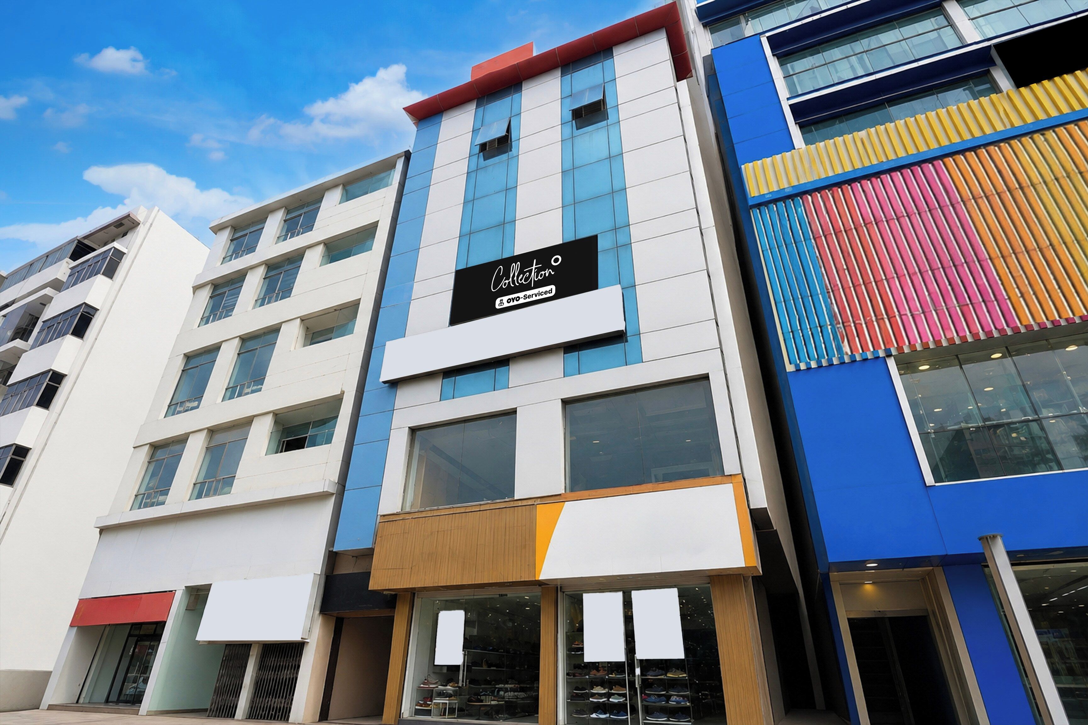 A multi-story building with a storefront featuring a sign that reads 'Collection OYO-Serviced'.