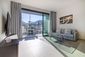 A modern living room with a sofa, a coffee table, and a glass dining table. - Mercury Tower Modern Apartment (St. Julian's)