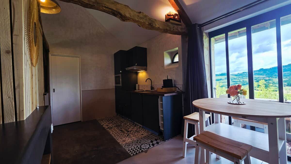 A compact kitchen with a window, a dining table, and a bench.