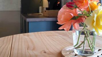 A wooden table with a clear glass vase containing flowers.