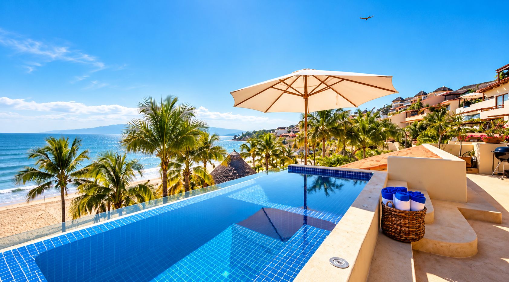 Una piscina con vista despejada a la playa y al océano, rodeada de palmeras y una sombrilla.