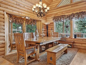 A log cabin interior with a wooden dining table, chairs, a bench, and a chandelier. - Chair 5 Chalet | True Ski In/ Ski Out + Hot Tub (Brian Head)