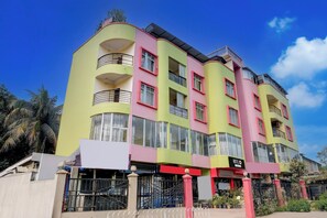 A multi-story hotel with balconies, large windows, and a sign indicating it is a hotel. - Hotel O Sankaradeva Kalakshetra (Guwahati)