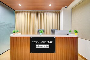 A reception desk with a sign that reads 'TOWNHOUSE OAK Company-Serviced.' - Townhouse Oak Miyapur Road Bachupally (Hyderabad)