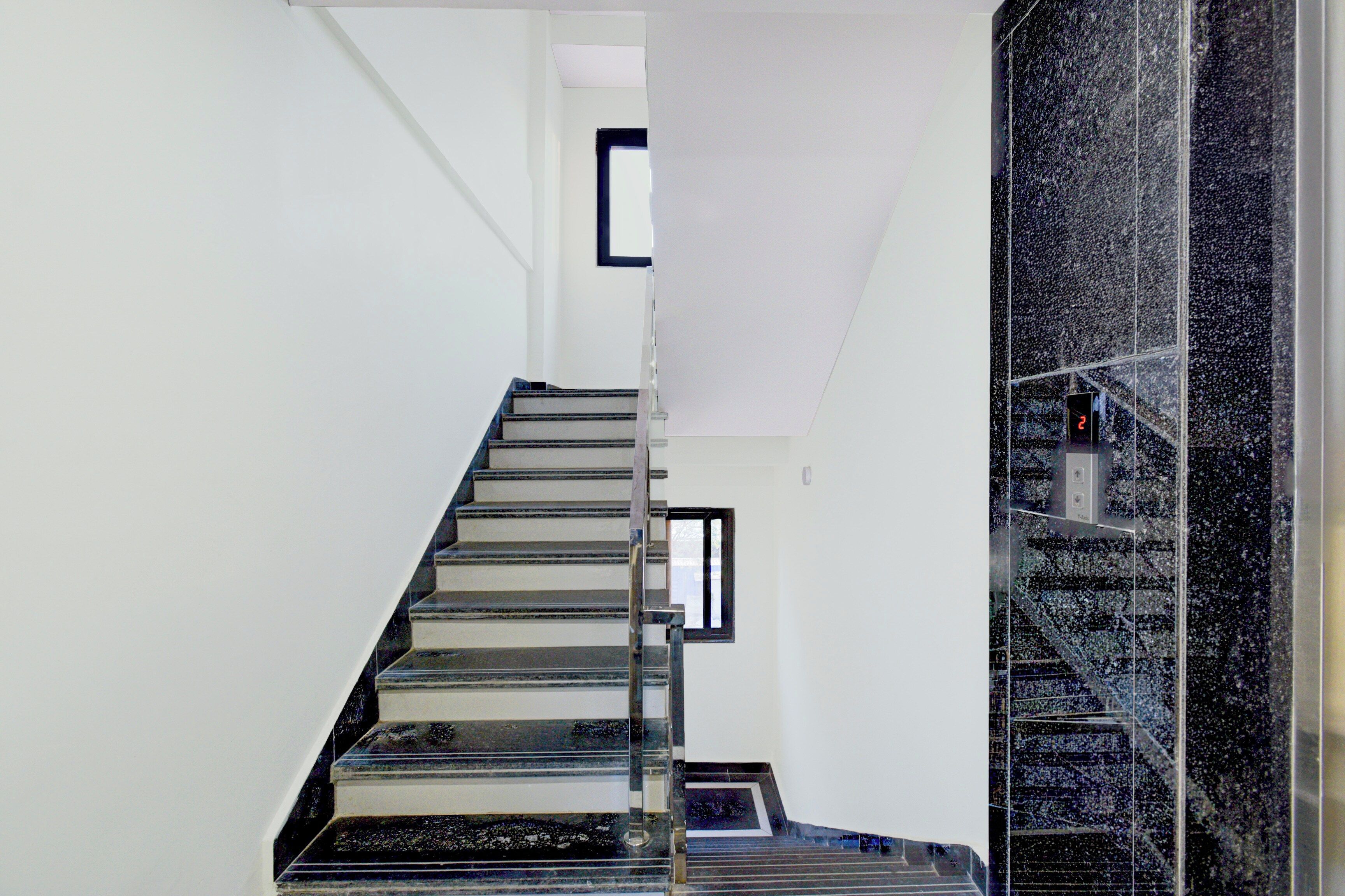 Una escalera con barandilla y un revestimiento de pared a blanco y negro.