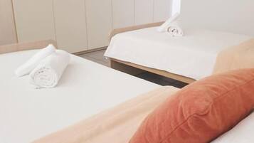 Een hotelkamer met twee bedden, een kledingkast en een raam.