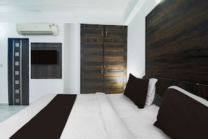 Ein Schlafzimmer mit Bett, Schrank, Tür und Klimaanlage.