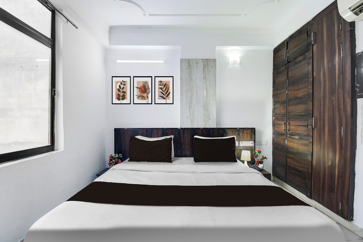 Ein Schlafzimmer mit einem Bett, einem Kleiderschrank, einem Nachttisch und Wandbildern.