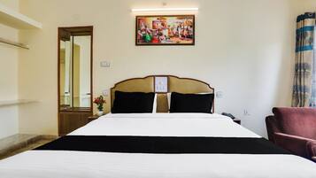 Een hotelkamer met een bed, een stoel, een schilderij aan de muur en een deur.