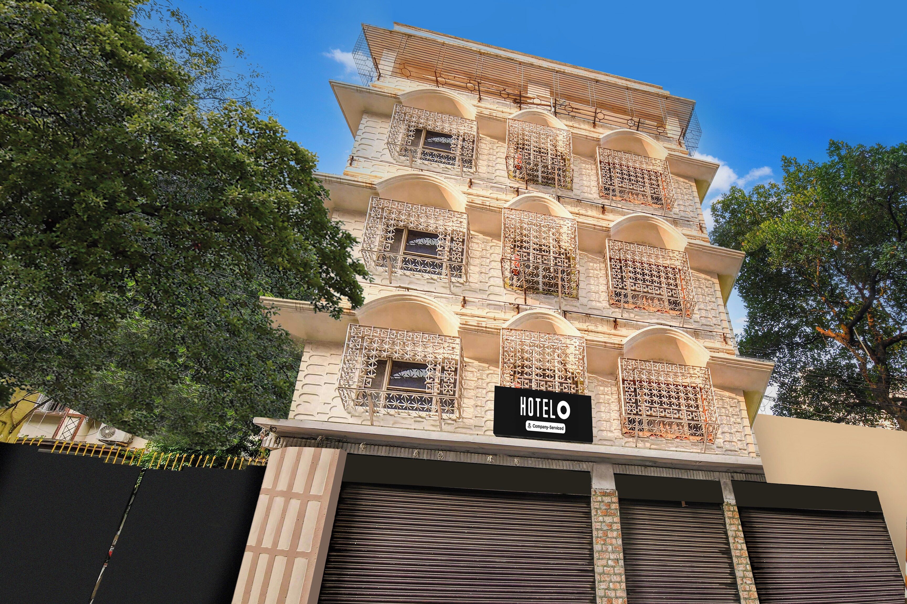 Un hotel de varios pisos con balcones, un cartel que indica que es un servicio de empresa y una puerta de garaje cerrada.