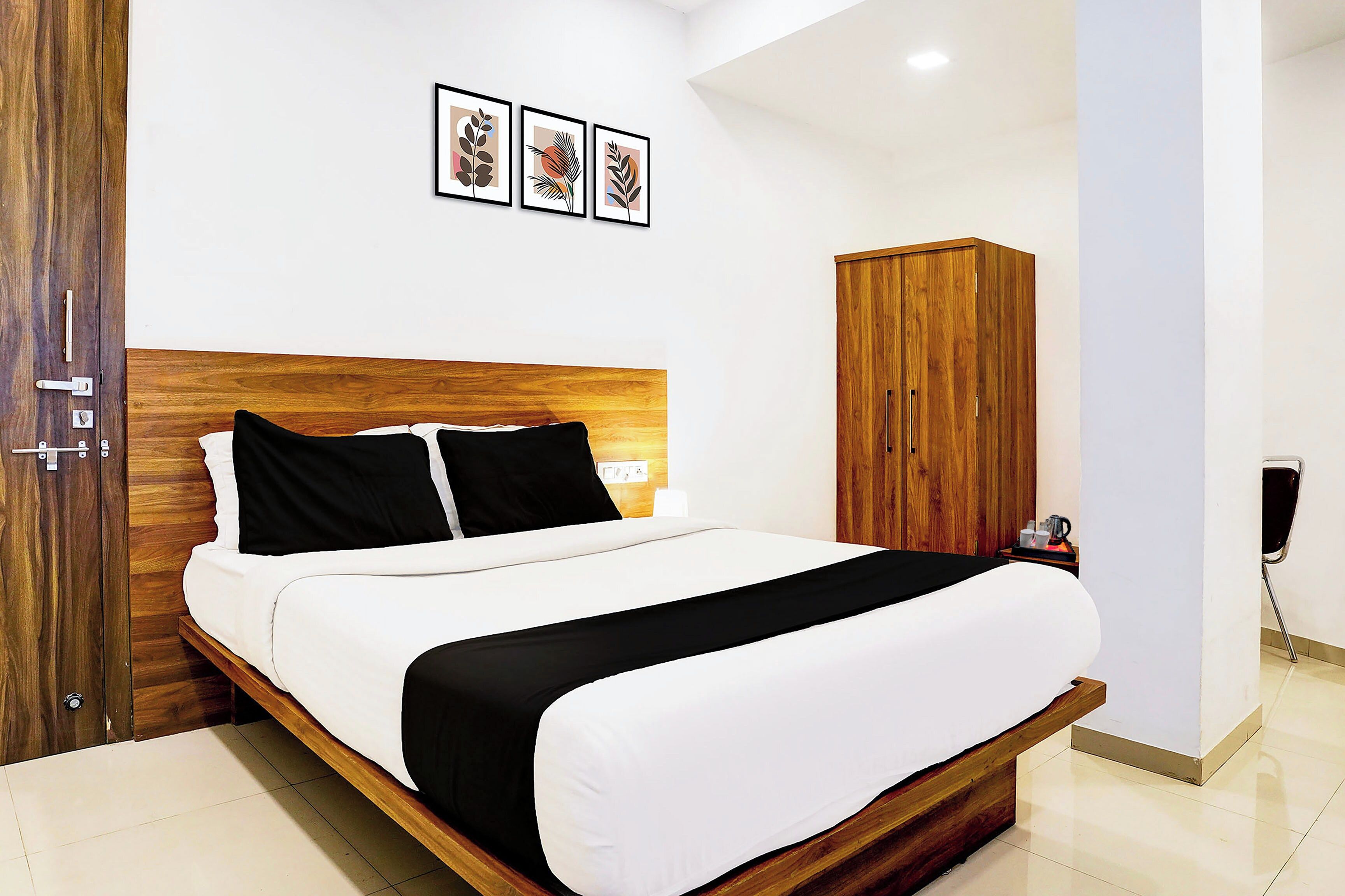 Een hotelkamer met een houten bed, een kledingkast en een aan de muur hangend schilderij.