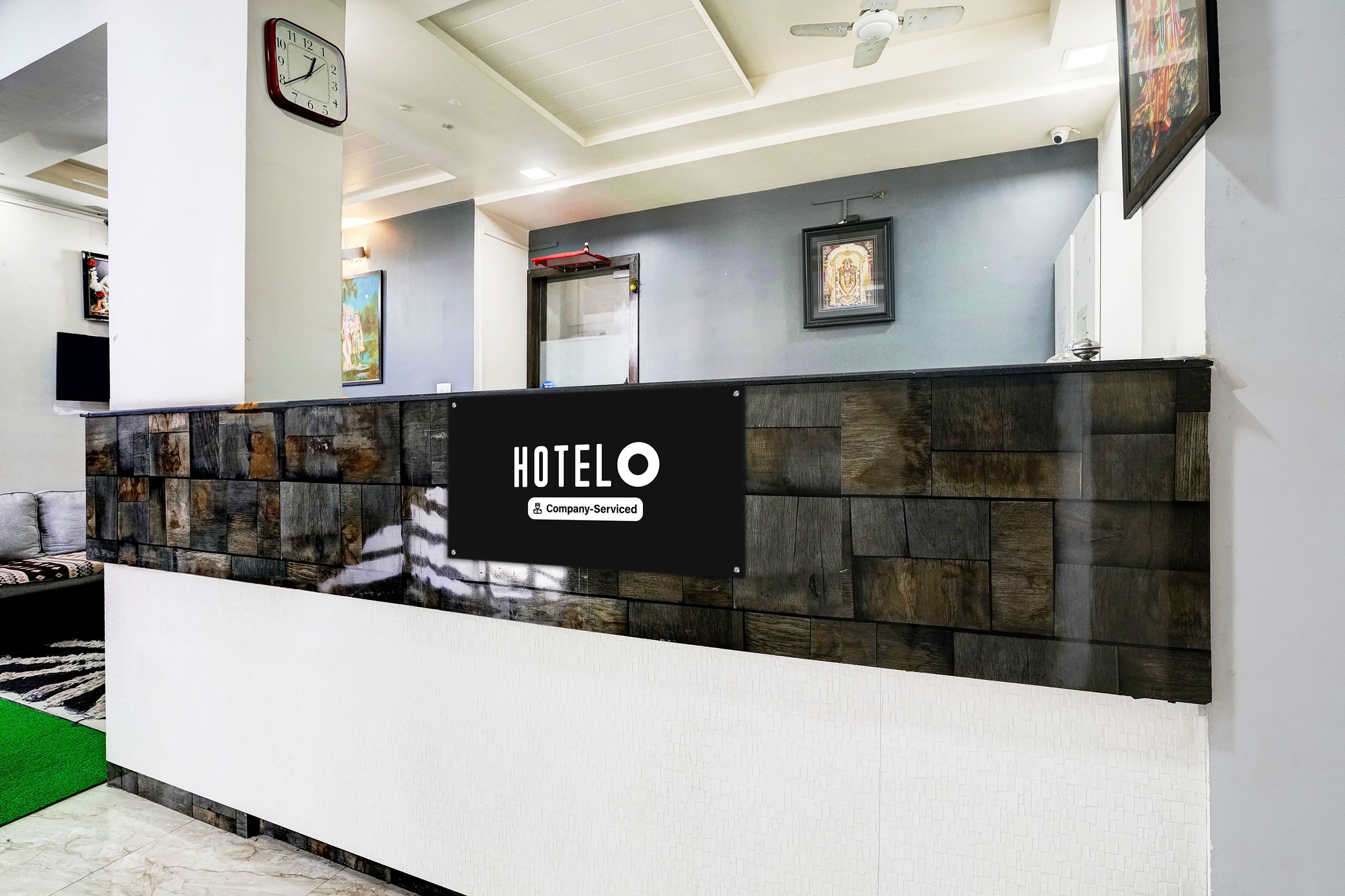A reception desk with a sign reading 'HOTELO' and a 'Company-Serviced' label.