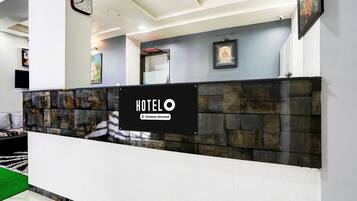 En receptionsdisk med en skylt där det står ”HOTELO” och en etikett med texten ”Företagsservice”.