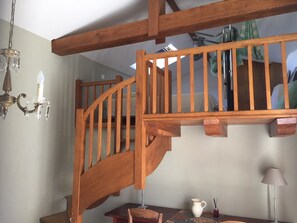 A wooden staircase with a chandelier and a table with a pitcher and candles. - Holiday Home 'Les Deux Indeaux' with Wi-Fi (Lusignac)