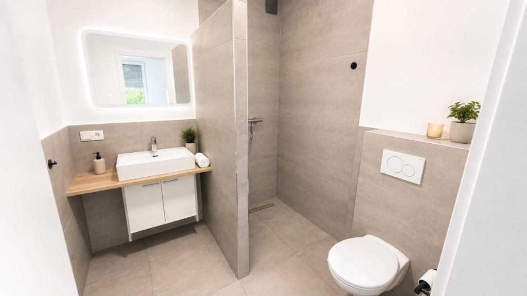 Un bagno moderno con doccia, wc e lavandino.