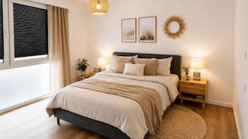 Quarto com cama, mesas de cabeceira, luminária pendente, janela com persianas e decoração na parede.