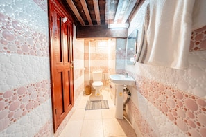 A bathroom with a toilet, sink, and a wooden door. - Dar fés (Fes)