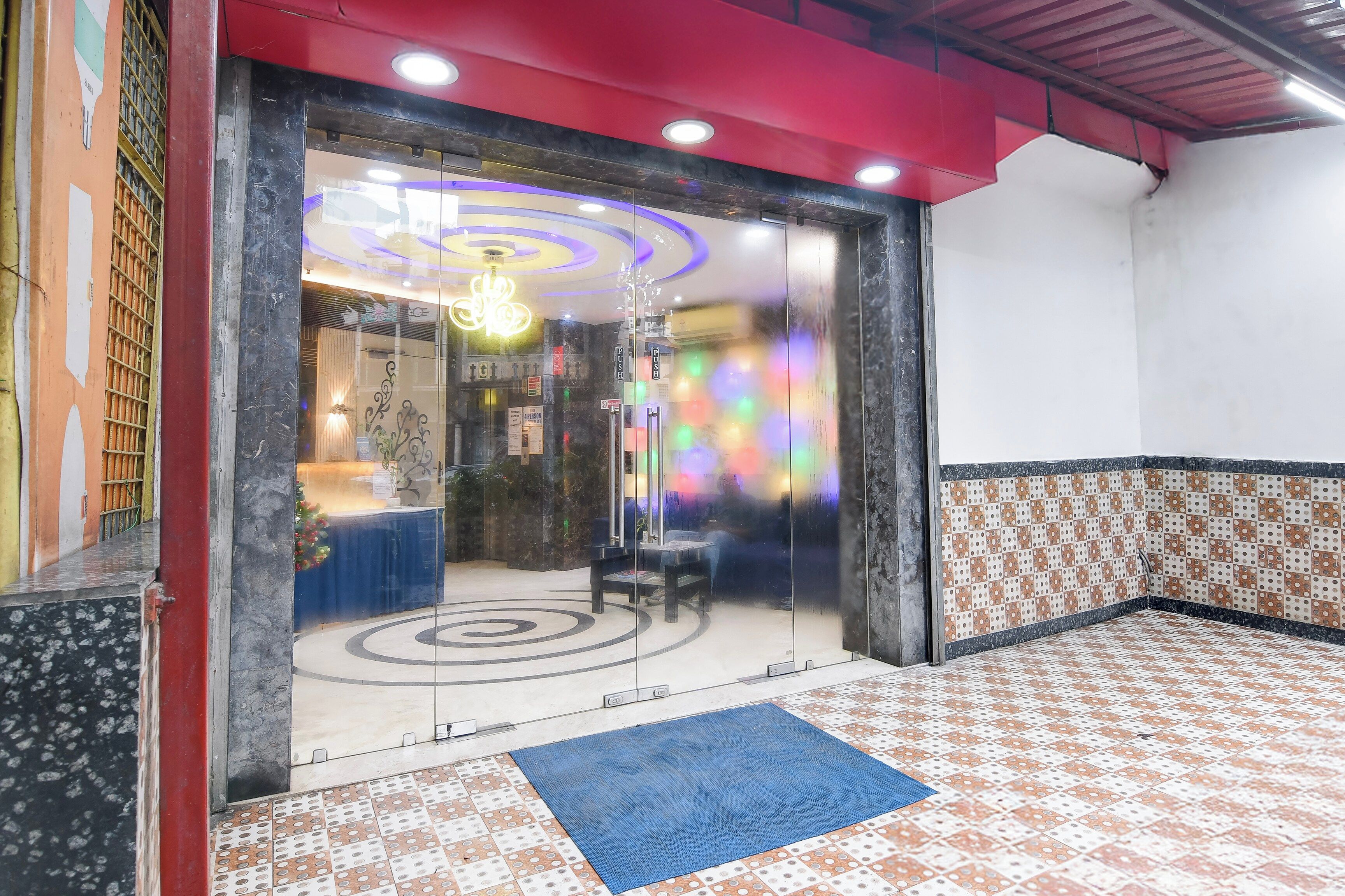 A hotel lobby with a reception desk, seating area, and a patterned floor.