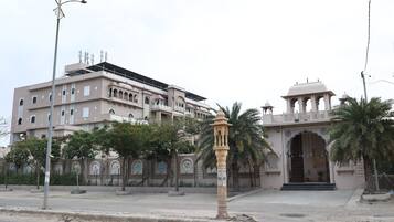 A building with a traditional architectural style, featuring arched windows and a central entrance with a decorative canopy.