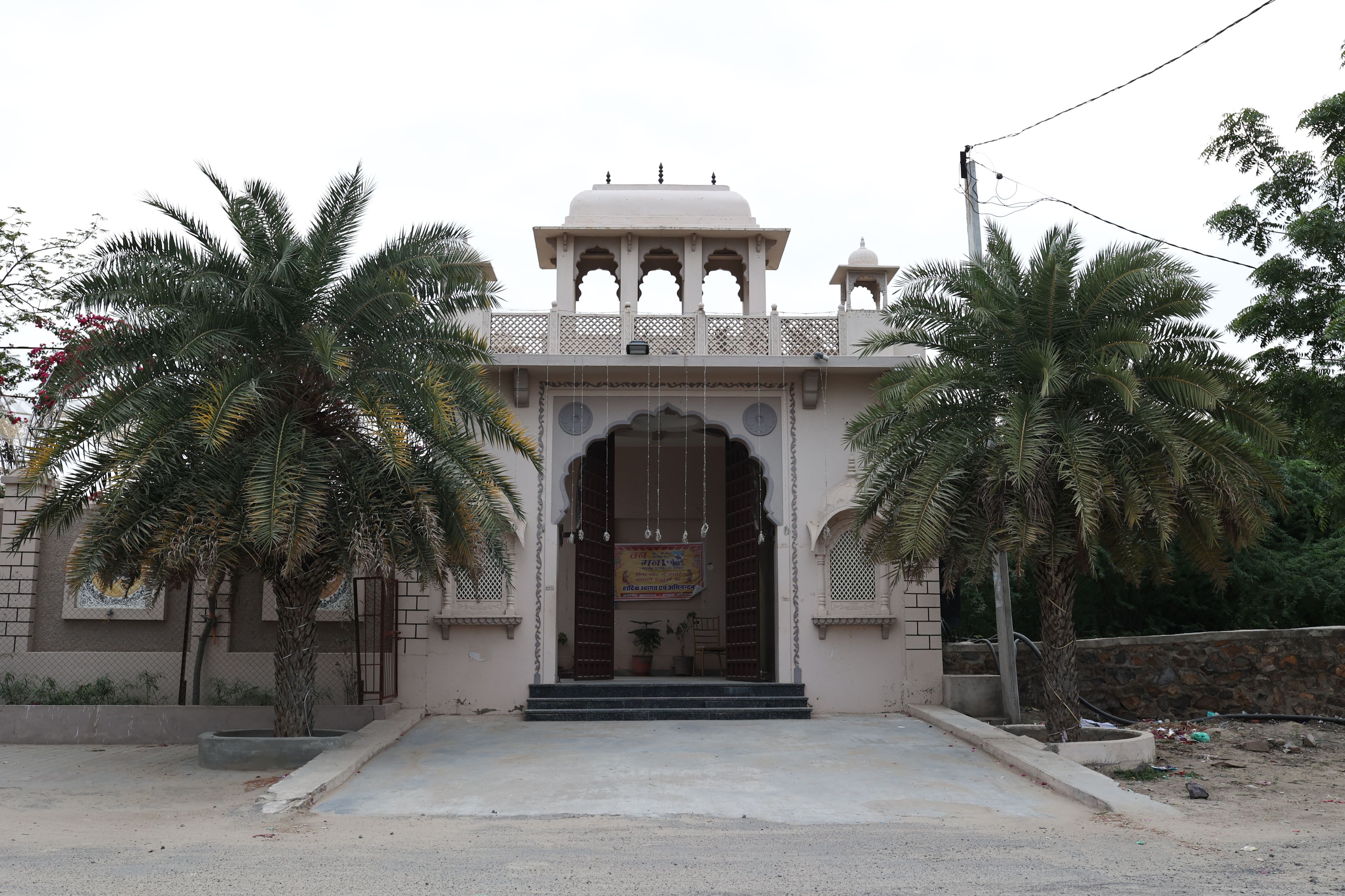 Un edificio tradicional con un arco central, una pequeña cúpula en la parte superior y un balcón con barandillas.