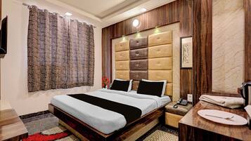 Una habitación de hotel moderna con una cama grande, una mesita de noche, un espejo y un baño.