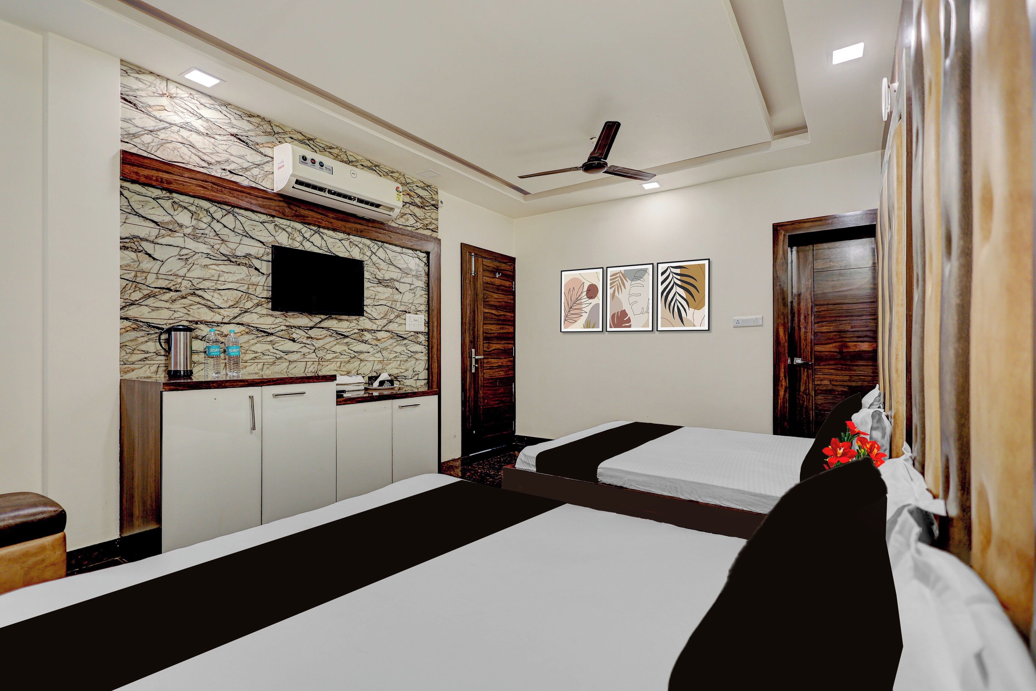 Habitación de hotel con cama, escritorio, televisión y aire acondicionado instalado en la pared.