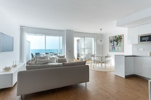A modern living space with a sofa, dining table, and kitchen area. - Luxury Seaview Isea 2231 by Casasol (Torrox)