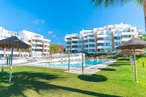 A resort with a swimming pool, lounge chairs, and modern buildings. - Luxury Seaview Isea 2231 by Casasol (Torrox)