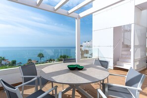 A round table with chairs in a balcony area with a view of the sea. - Luxury Seaview Isea 2231 by Casasol (Torrox)