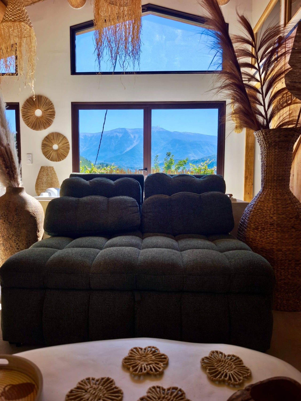 Quarto com cama grande, duas janelas e vista para montanhas.